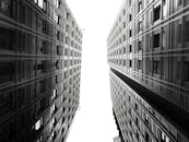 低角度拍摄的现代摩天大楼，其玻璃和钢立面呈现出对称美感