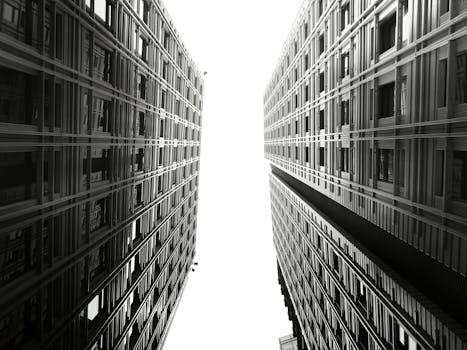 低角度拍摄的现代摩天大楼，其玻璃和钢立面呈现出对称美感