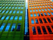 这座现代建筑引人注目，立面采用绿色和橙色，并配有反光玻璃窗