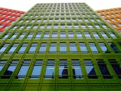 低角度拍摄的彩色城市建筑立面，带有现代风格的反光窗