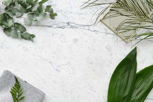 Free Top view of a marble surface with green leaves and a mirror, perfect for backgrounds. Stock Photo