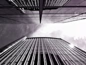 现代玻璃摩天大楼高耸入云，在多云的天空下呈现出戏剧性的景象