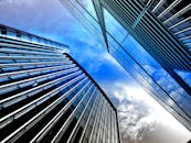 低角度视角下的现代摩天大楼，反光玻璃映衬着明亮的蓝天