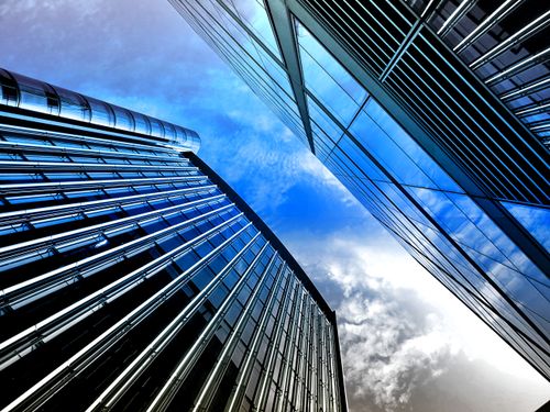 Free Low angle view of modern skyscrapers with reflective glass against a bright blue sky. Stock Photo