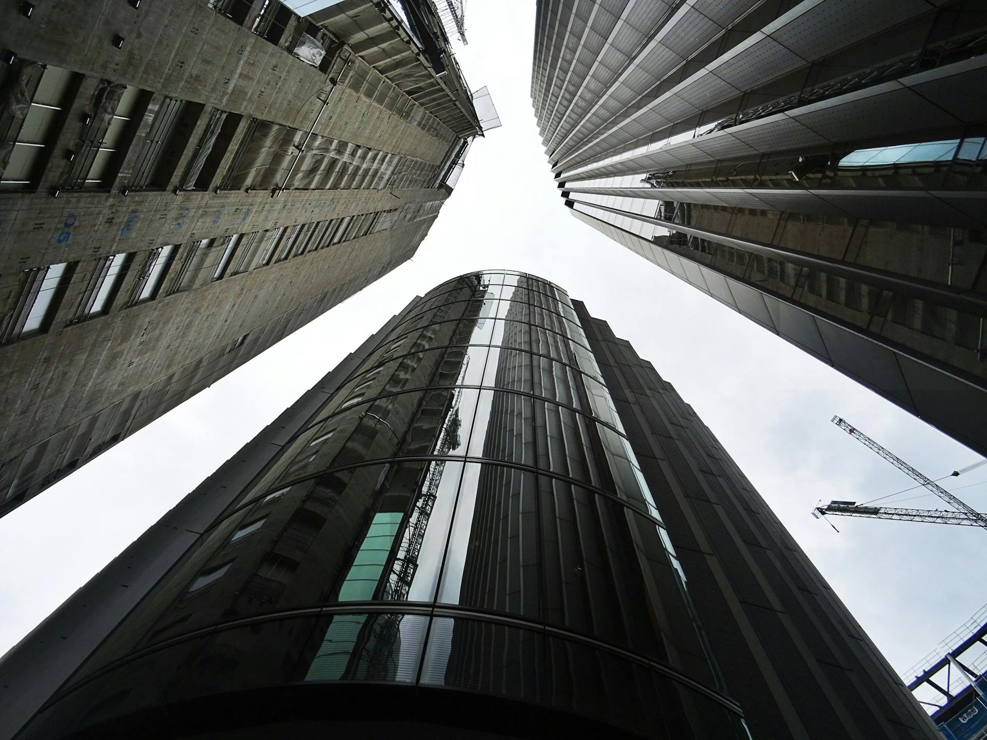 Dynamic low-angle view of futuristic skyscrapers with glass and steel architectural design in cityscape.