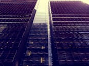 低角度拍摄的现代摩天大楼，具有反光玻璃立面，与城市建筑相映成趣