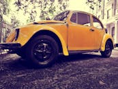 一辆经典的黄色大众甲壳虫停在街上，营造出怀旧的复古氛围