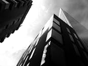 低角度黑白照片通过反光玻璃捕捉现代城市摩天大楼