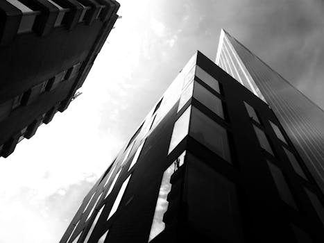 低角度黑白照片通过反光玻璃捕捉现代城市摩天大楼