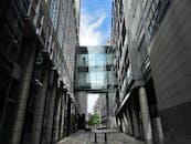 这张低角度镜头拍摄的现代建筑引人注目，其特色是摩天大楼之间的玻璃桥