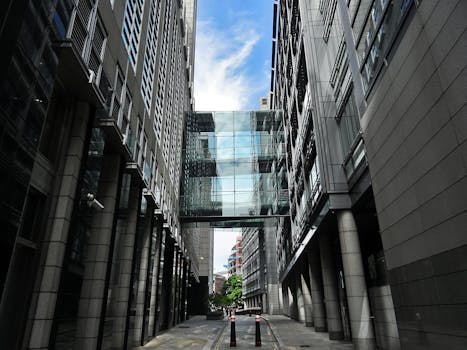 这张低角度镜头拍摄的现代建筑引人注目，其特色是摩天大楼之间的玻璃桥