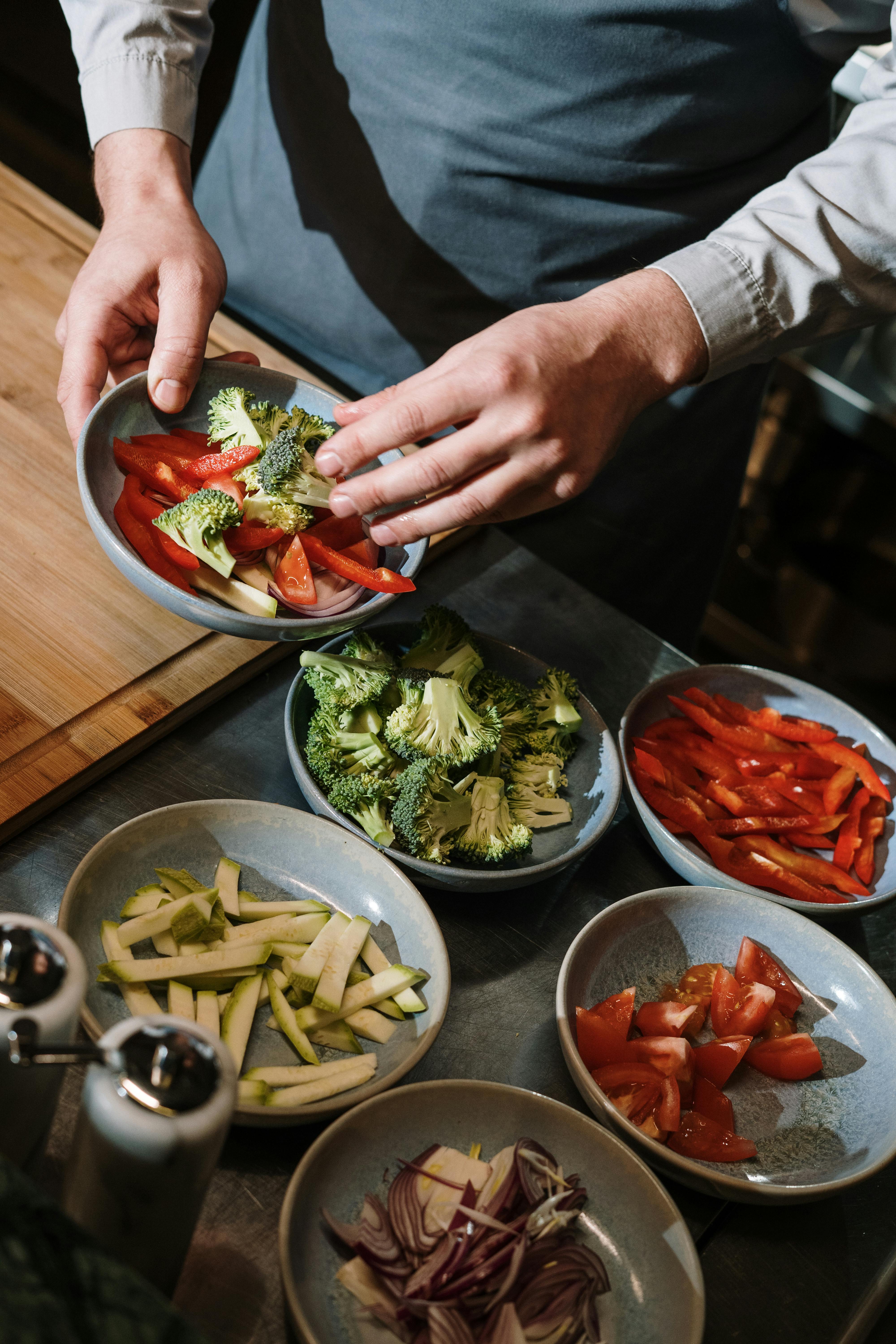 person holding red ceramic plate with food