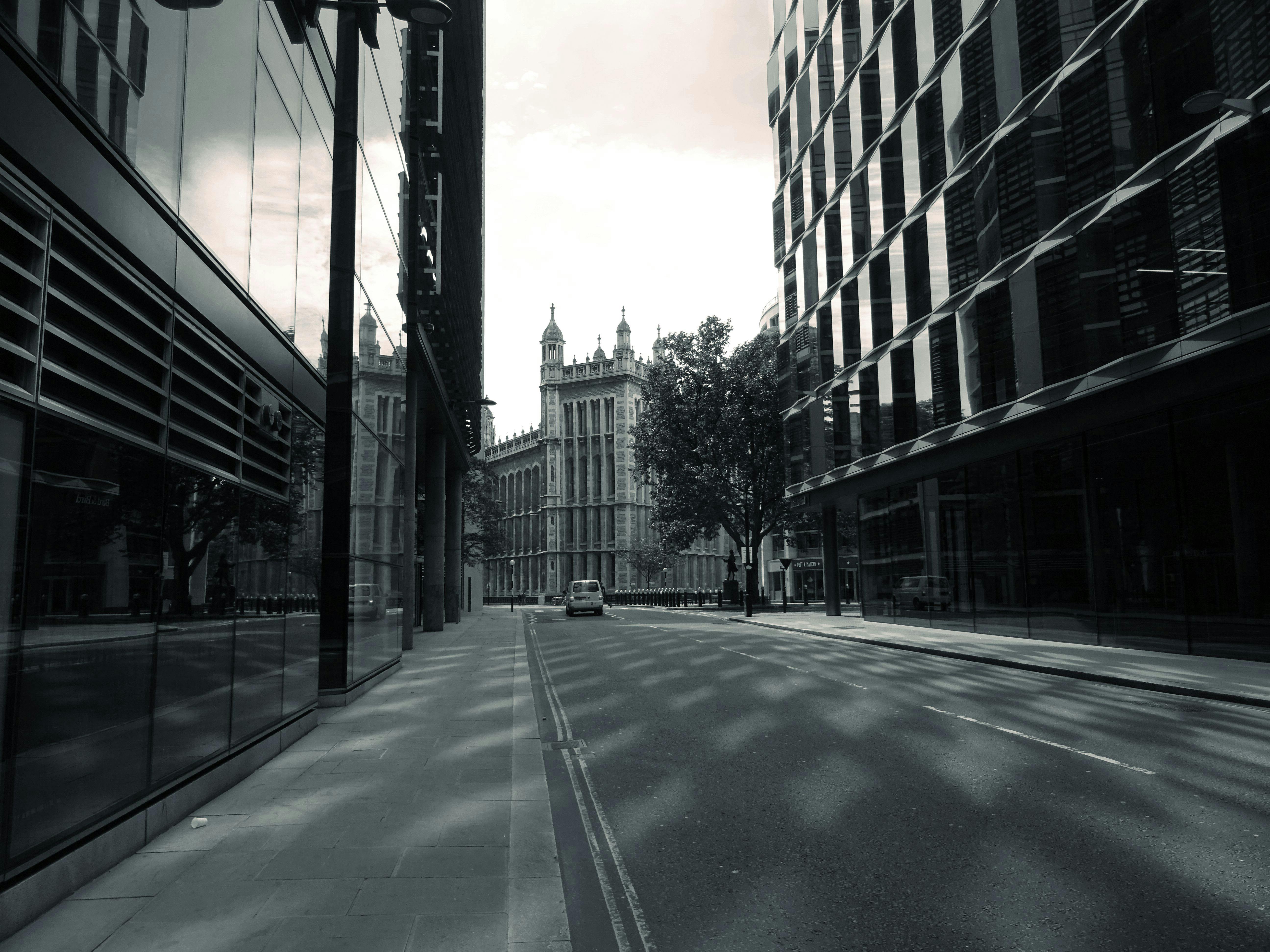 一条宁静的城市街道上，现代与历史建筑倒映水中，鹅卵石小路蜿蜒其间