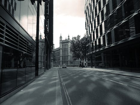 一条宁静的城市街道上，现代与历史建筑倒映水中，鹅卵石小路蜿蜒其间