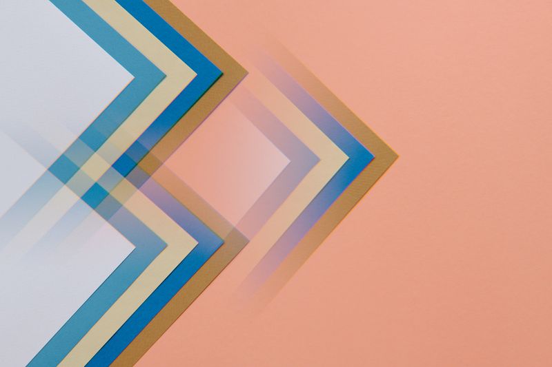 Abstract design featuring overlapping geometric shapes in soft pastel colors on a peach background.