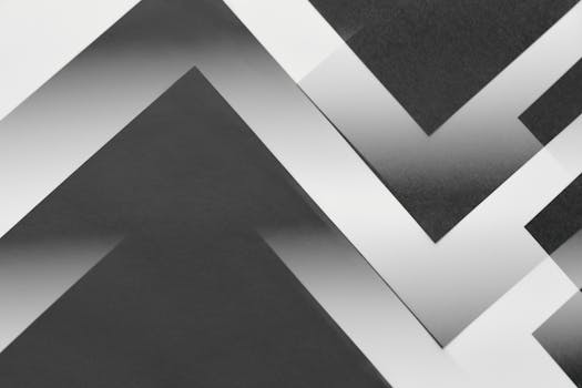 A minimalist abstract design featuring zigzag patterns in monochrome tones.