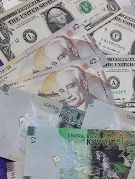 成堆的美元和科威特第纳尔纸币，象征着国际金融与货币交换