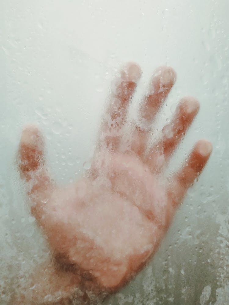 Crop Person Putting Hand On Misted Glass