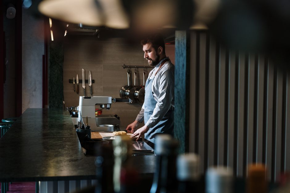 A skilled chef preparing ingredients in an industrial kitchen setting.
