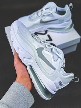 Close-up of a modern Nike sneaker being held, showcasing its sleek design and brand logo.