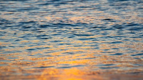 Free Capture of gentle ocean waves reflecting the warm hues of the sunset on Gold Coast, Australia. Stock Photo