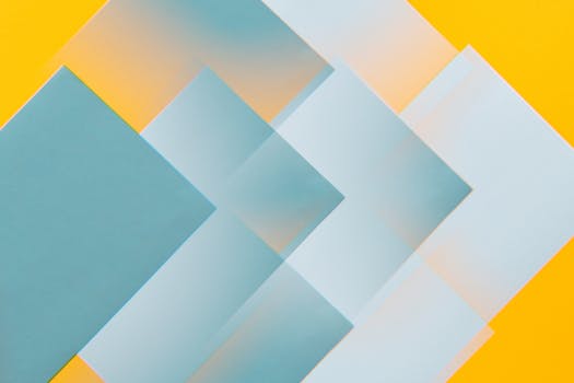 Modern abstract art featuring overlapping geometric shapes in teal and yellow tones.