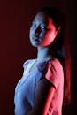 Young ethnic lady standing under neon illumination