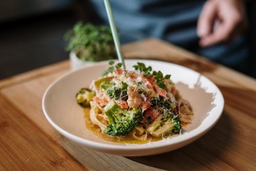A mouthwatering plate of Italian pasta with fresh broccoli and tomatoes garnished with herbs.