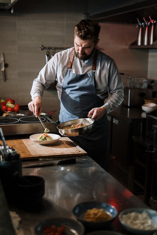 Man in White Long Sleeve Shirt Holding Stainless Steel Cooking Pot