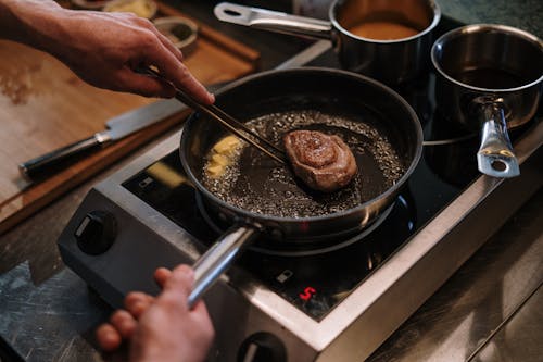 Free Person Cooking on Black Frying Pan Stock Photo