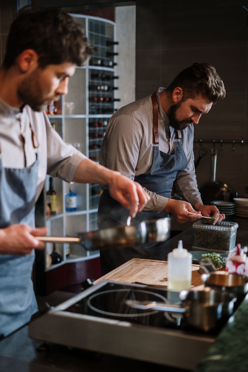 Cuisiniers en tablier professionnel dans une cuisine de restaurant, illustrant les matières couramment utilisées