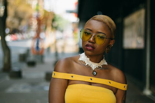 Close-Up Shot of a Woman in Yellow Outfit Wearing Yellow Sunglasses