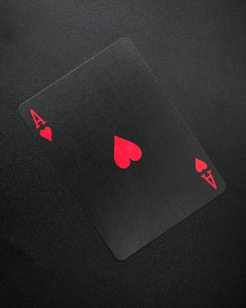 Free Close-up of an ace of hearts playing card on a black background, symbolizing luck. Stock Photo