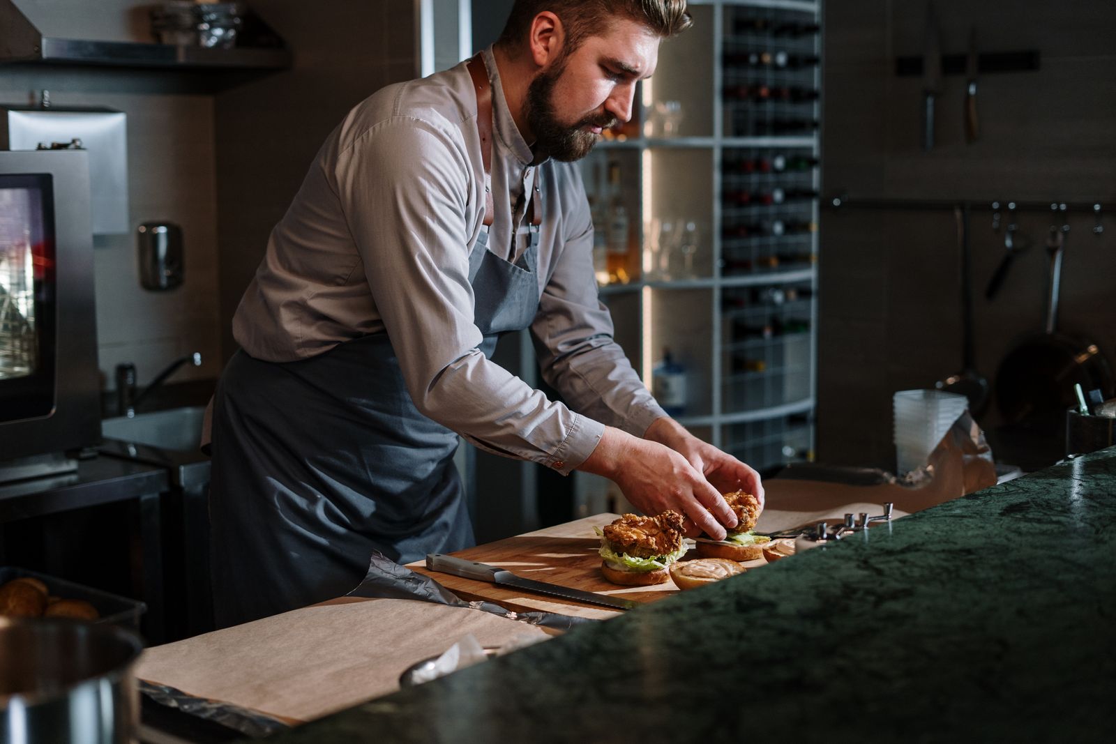 Chef preparing a gourmet beef burger in the FUEL kitchen