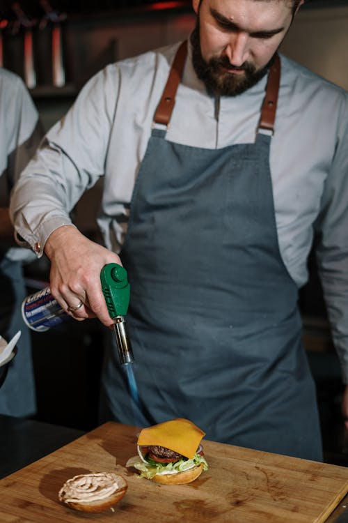 Man in White Dress Shirt Holding Green and Silver Hand Tool