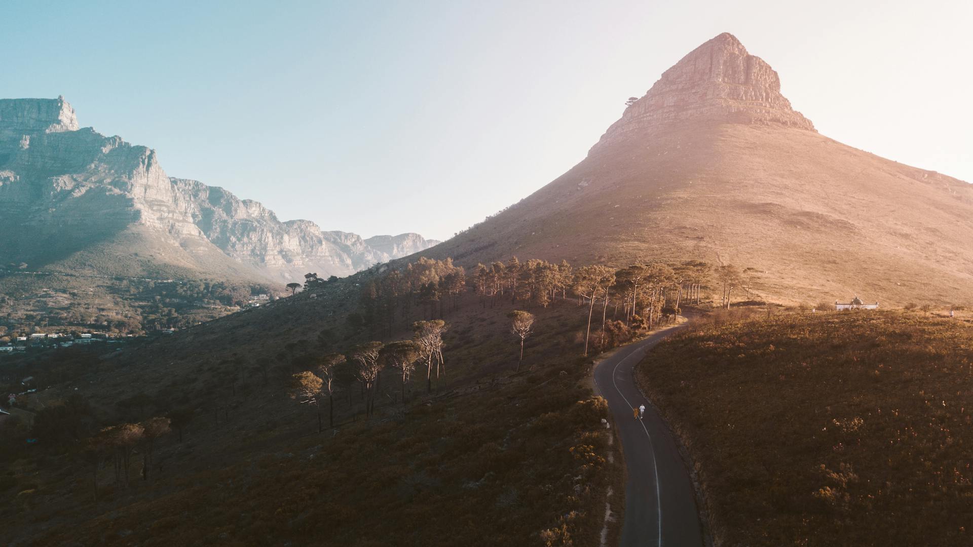 Stunning aerial view of Lion's Head in Cape Town at sunrise, showcasing the beautiful natural scenery and winding roads.