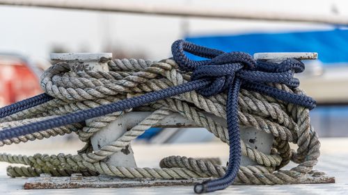 Free Close up of nautical knot ropes tied around metal bollard on modern ship deck Stock Photo