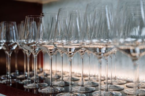 Free Row of crystal wine glasses neatly arranged on a shelf, highlighting elegance and luxury. Stock Photo
