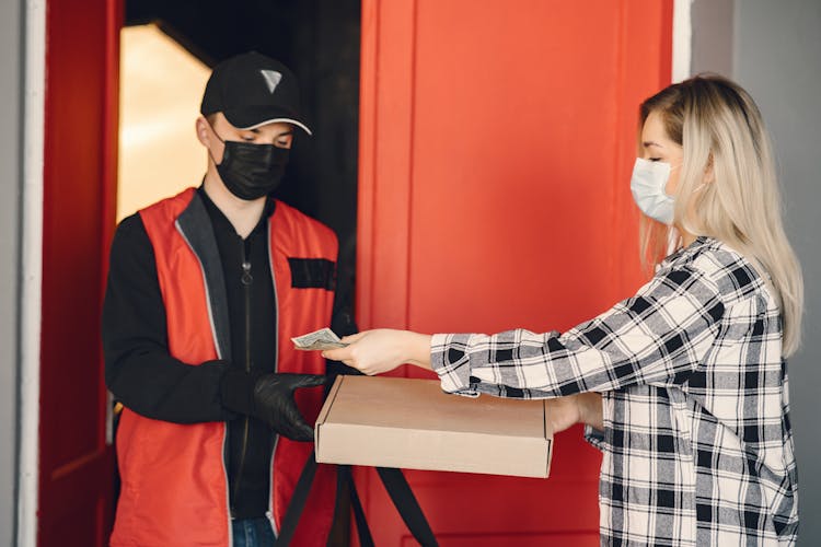 Young Female Customer Receiving Pizza During Coronavirus Pandemic Quarantine