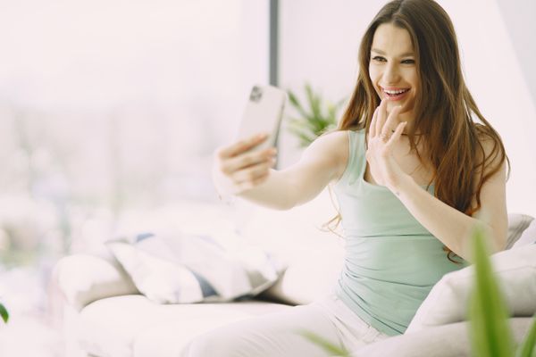 A woman smiling during a video call on her phone