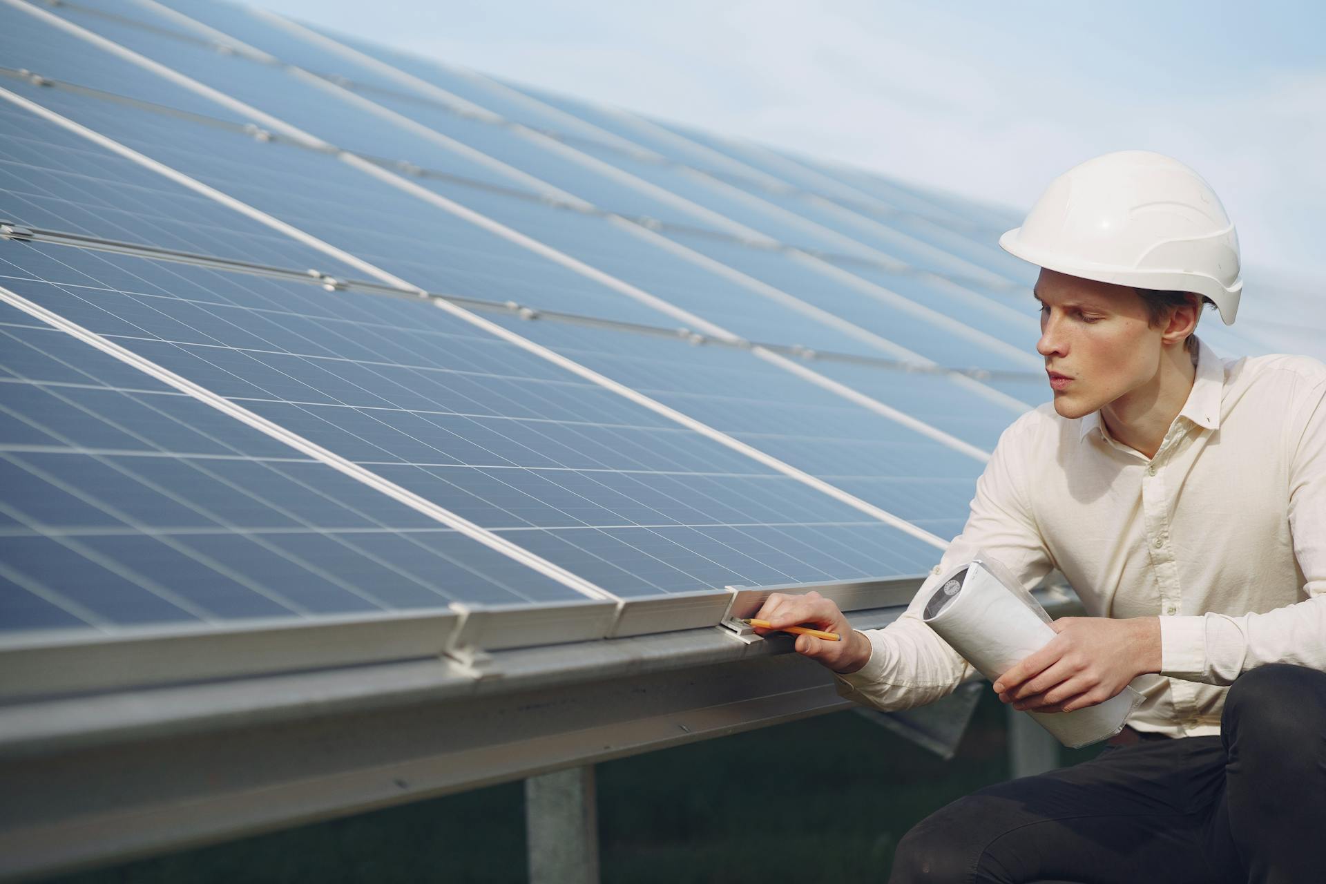 Engineer performing maintenance on solar panels for renewable energy sustainability.