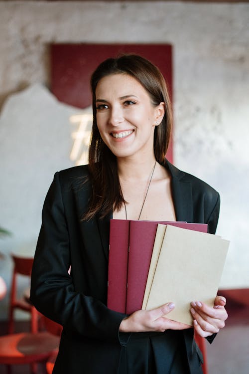 Free Woman in Black Blazer Holding Red Book Stock Photo