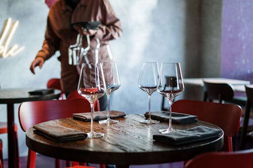 Free Man in Brown Jacket Sitting Beside Table With Wine Glasses Stock Photo