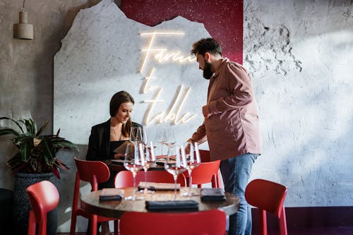 Man in Brown Dress Shirt Standing Beside Woman in Red Dress