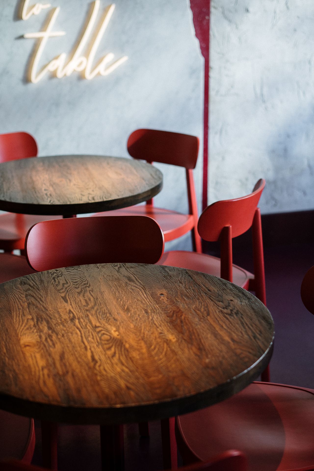 Round wooden table with red chairs