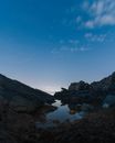 星空下，宁静的夜间沿海风光中，海岸多岩石