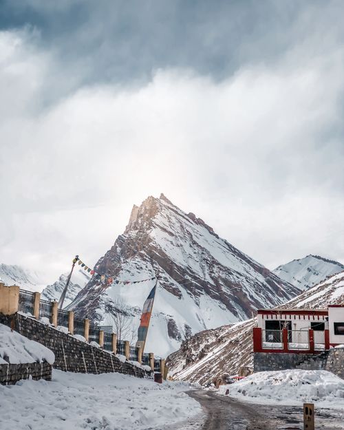 Free Rocky summit of remote mountain in range with road and fence under gloomy clouds Stock Photo