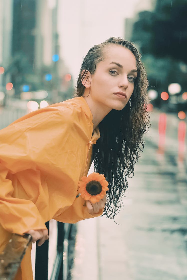 Young Woman With Flower Under Rain In Downtown