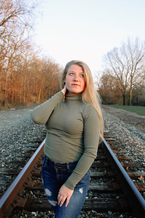 Casual blonde on railroad in autumn nature