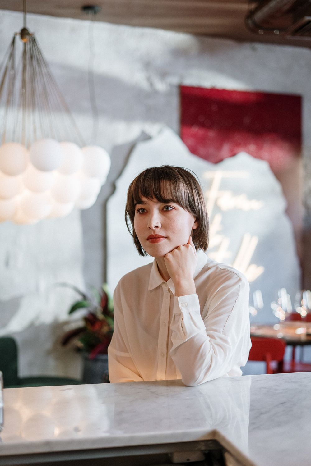 Woman in White Long Sleeve Shirt Sitting on Chair · Free Stock Photo